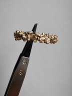 14K Golden ring with dense textured surface all around held by pincet.